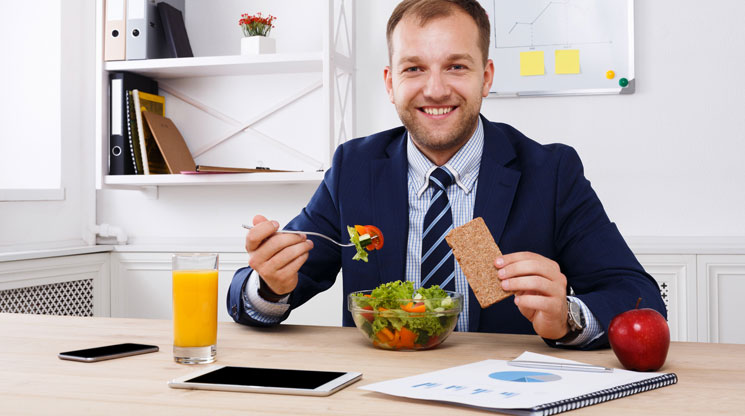 Man eating healthy lunch at work